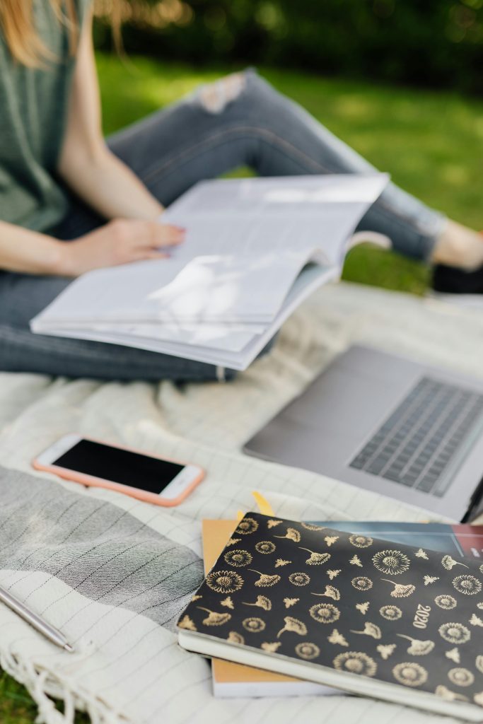 Crop student preparing homework in park